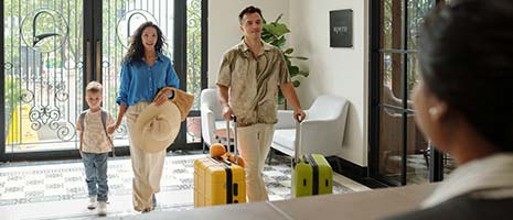 family checking into hotel at reception desk